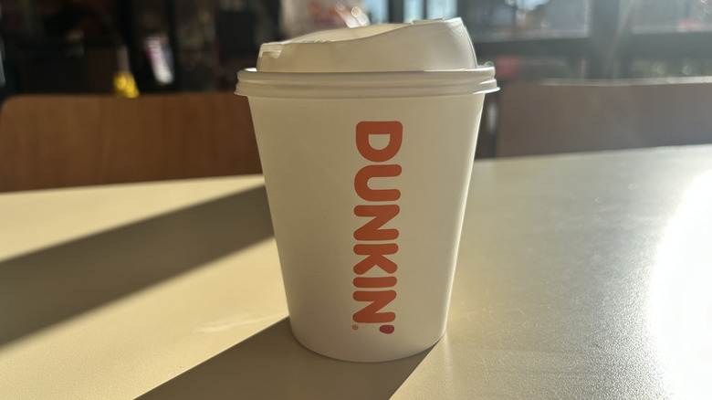 One Dunkin' coffee cup on a table