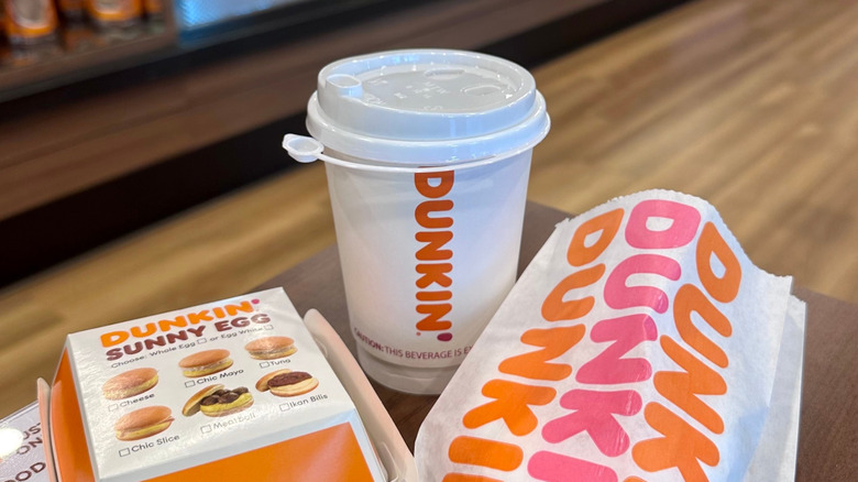 dunkin coffee and breakfast food wrapped and sitting on table