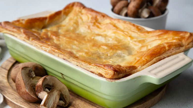 Rectangular pot pie next to sliced mushrooms