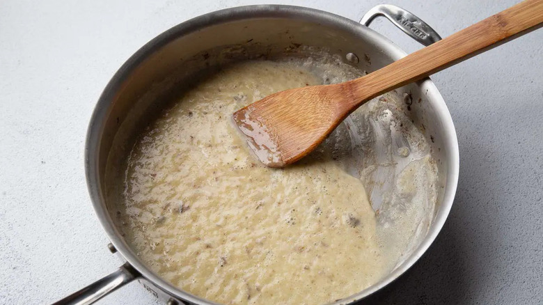 Buttery flour mixture in skillet with wooden spatula