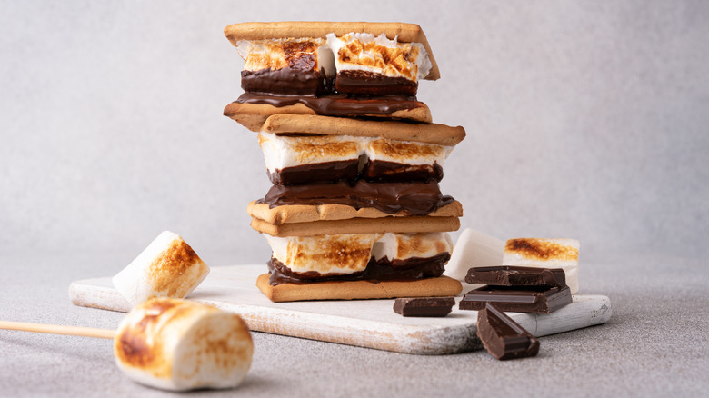 A stack of s'mores sitting on a cutting board.