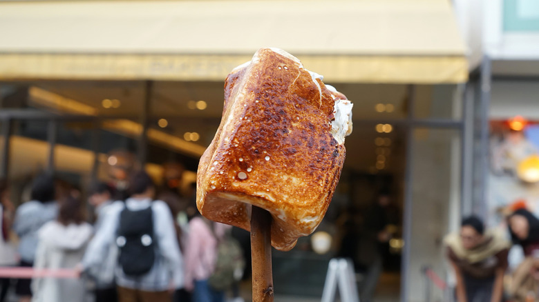 A toasted marshmallow speared on a stick.