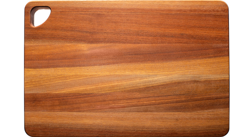 An edge-grain wooden cutting board on a white background.