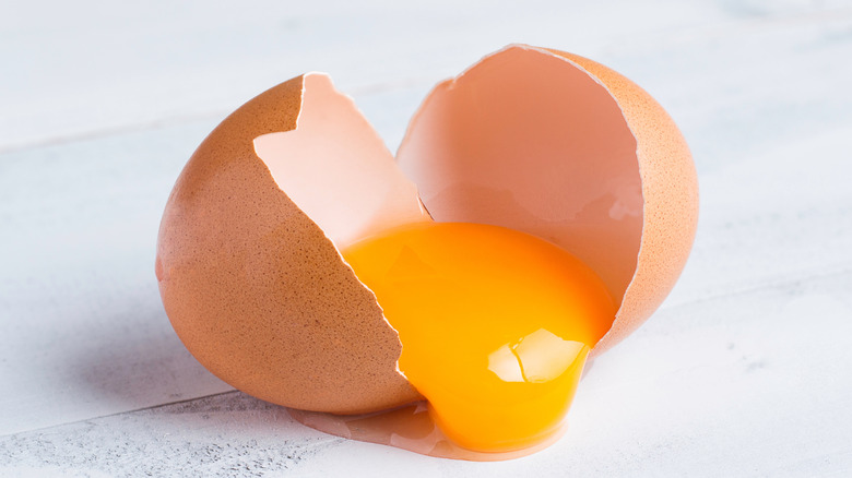 Broken egg with yolk in the middle