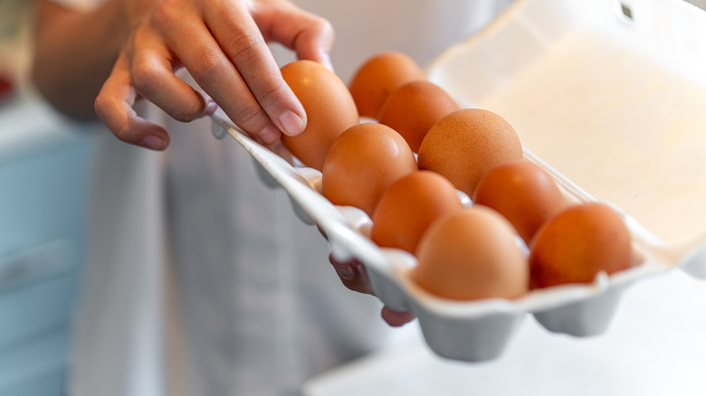 Person taking egg from box