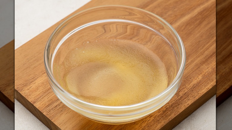 Ramekin of gelatin on wooden cutting board