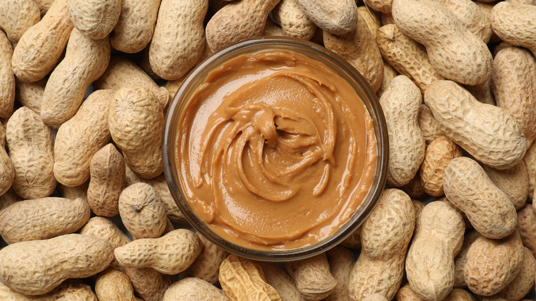 Peanut butter ramekin on bed of whole peanuts