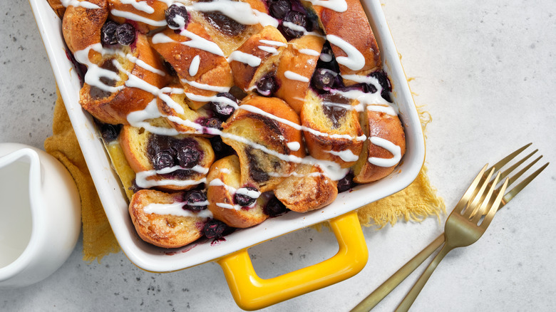 Blueberry French toast bake in a yellow casserole dish on a white counter