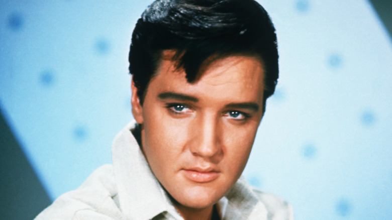 A close up photo of Elvis Presley with a blue background