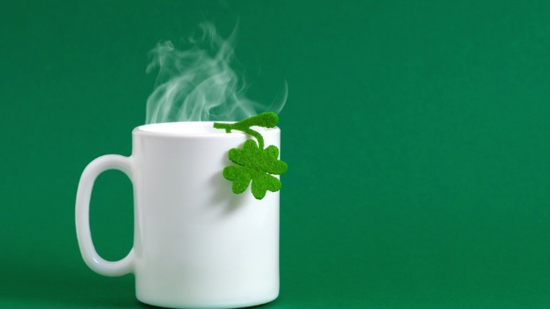 A mug of tea with a shamrock garnish.