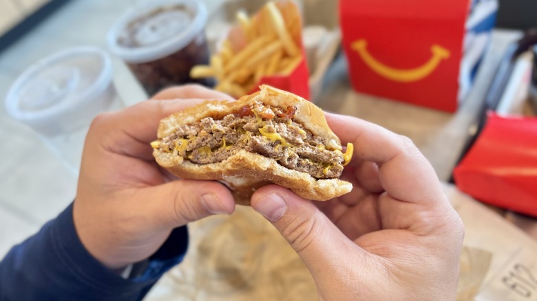 Hands holding a Triple Cheeseburger