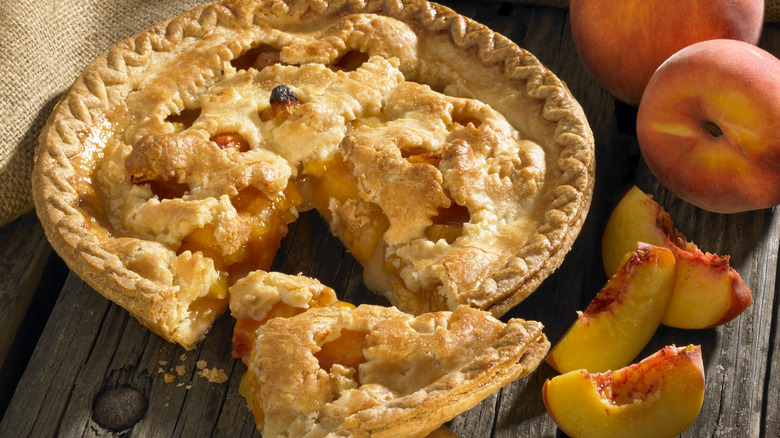 sliced peach pie on wooden table