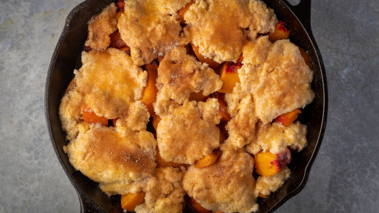 overhead closeup of a peach cobbler in cast iron skillet