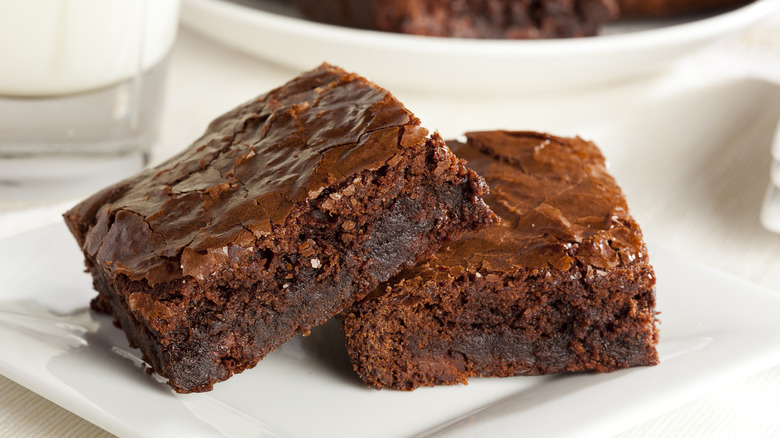 closeup of two fudgy brownies on white plate