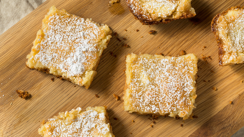 squares of butter cake on wooden board with powdered sugar