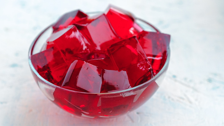 bowl of red Jell-O cubes on white background