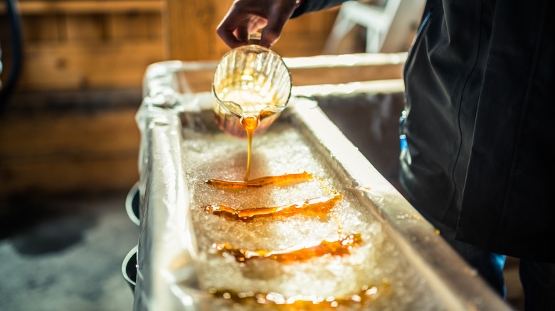 maple syrup being poured onto snow in sugar shack