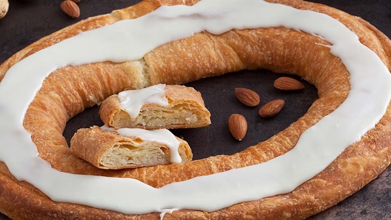 closeup of a danish kringle with almonds and frosting