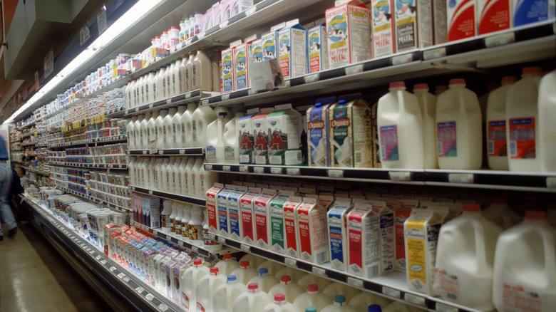 Grocery store aisle with various brands and types of milk