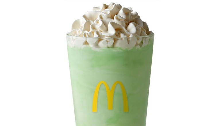 A green McDonald's Shamrock Shake in a glass with yellow M logo