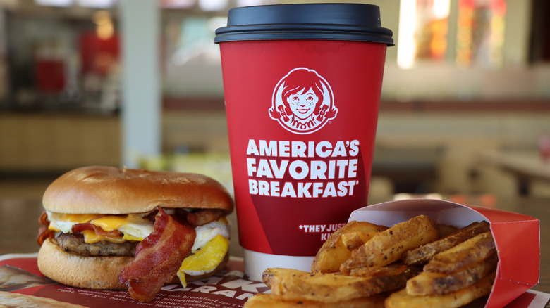 Bacon in Wendy's breakfast burger with coffee and potato wedges