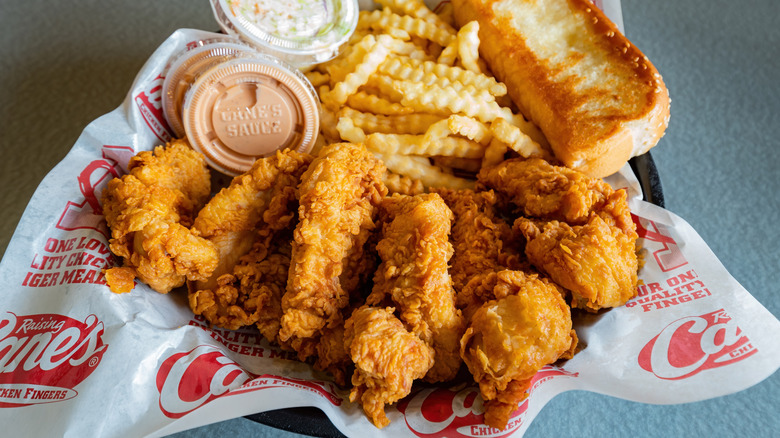 Chicken, fries and toast in basket with sauces at Raising Cane's