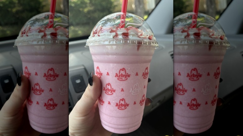 Hand holding strawberry Arby's milkshake