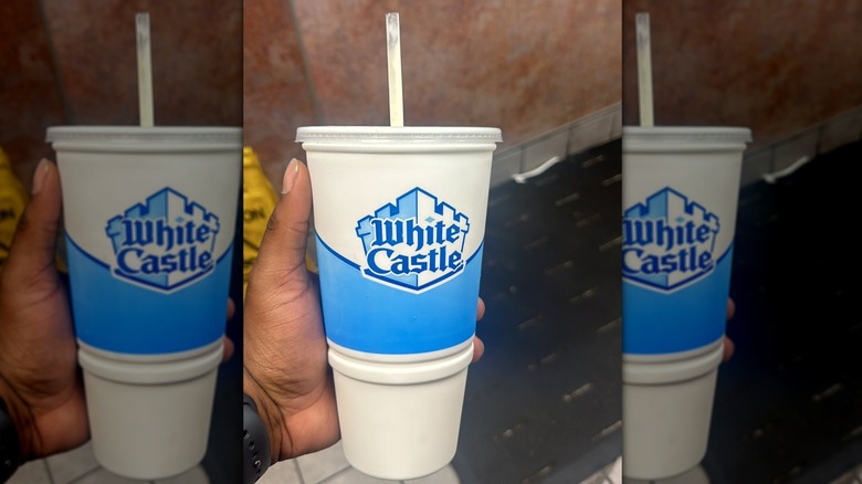 Hand holding White Castle milkshake in cup