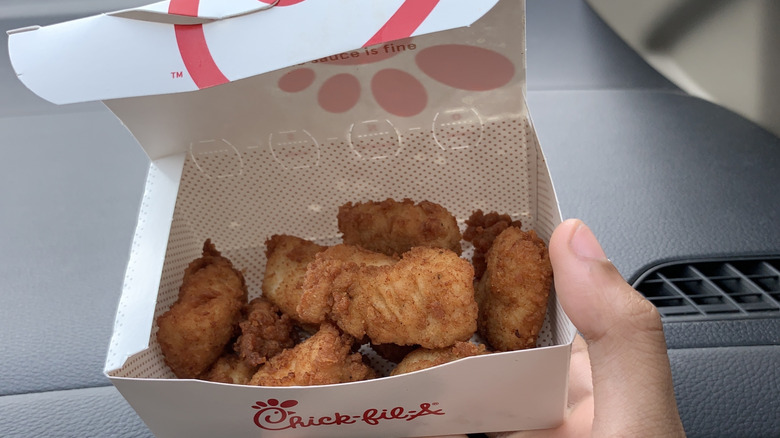 Hand holding box of chicken nuggets at Chick-fil-A