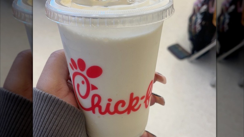 Hand holding big frosted lemonade from Chick-fil-A