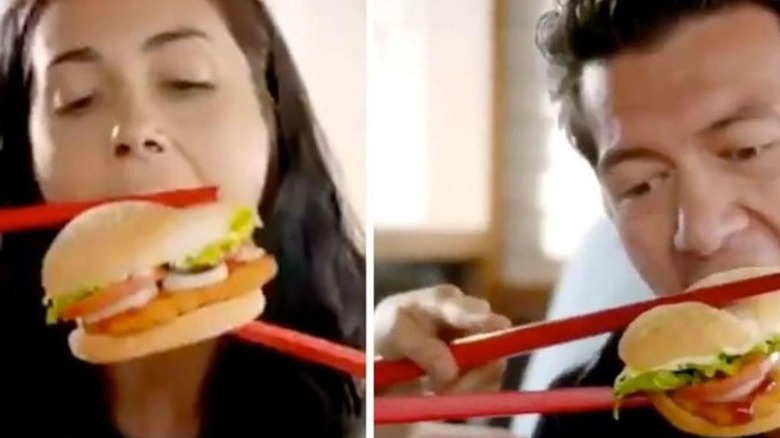 people eating burgers with chopsticks