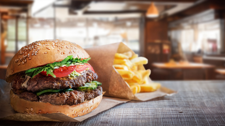 Burger with two patties and buns with french fries