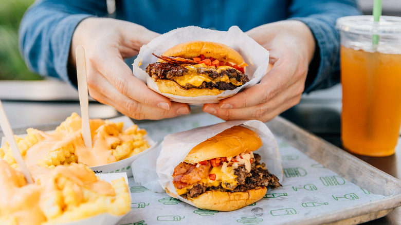 Hands holding burger from Shake Shack