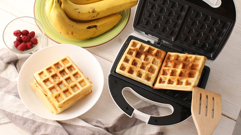 A person making waffles in a waffle maker