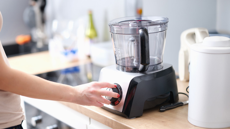 woman turning on food processor