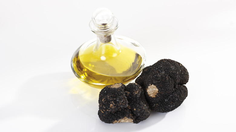 Truffle oil next to truffle mushrooms