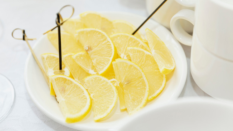 Lemon slices on white plate with toothpicks