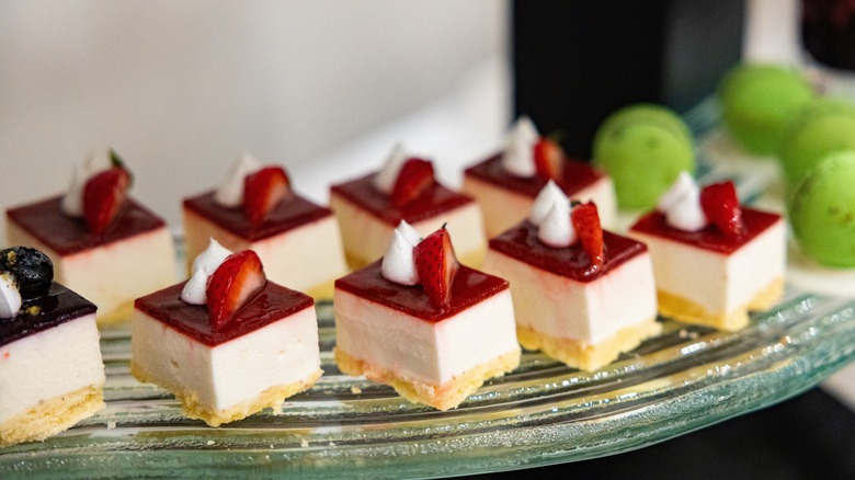 Mini strawberry cheesecake desserts on cake tray at buffet