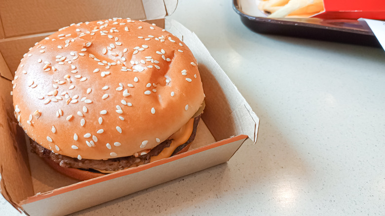 a mcdonald's burger in an open container on a table