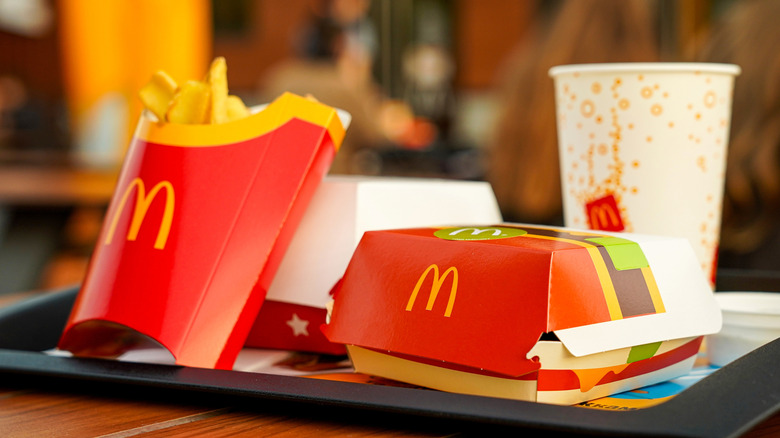 trays of mcdonald's food and sodas resting on the front counter of a restaurant