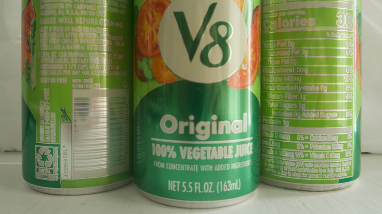 Three green cans of V8 juce.