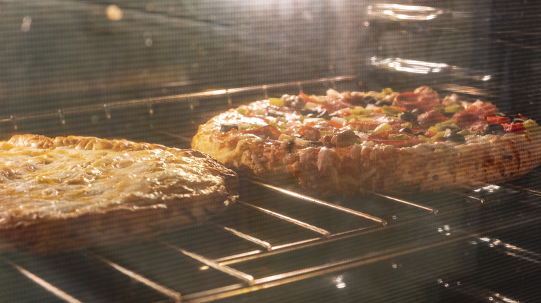 Frozen pizzas cooking on a rack in the oven