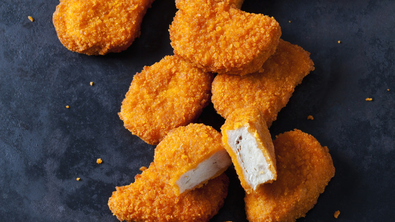 Close-up of crispy chicken nuggets on a black background