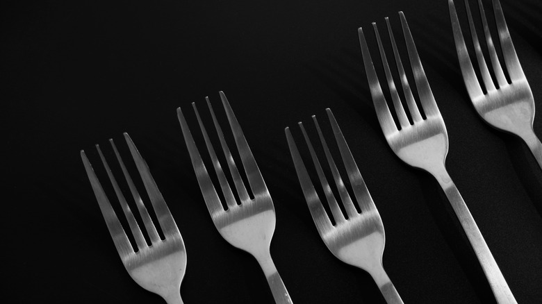 five forks on a dark background