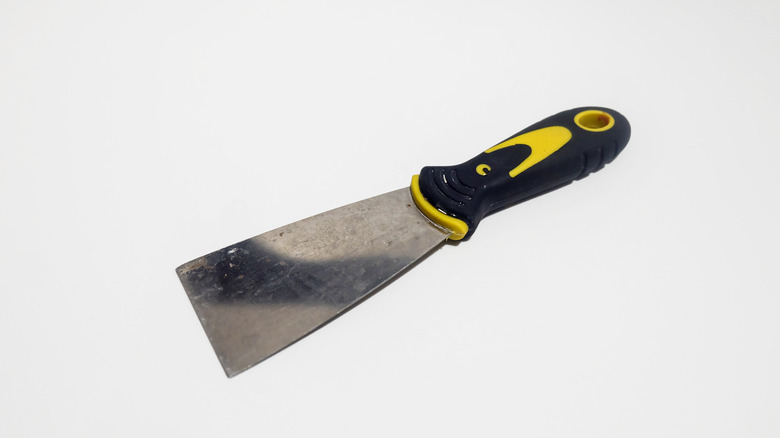 a black and yellow putty knife