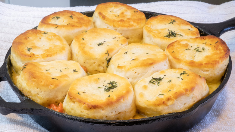 Chicken pot pie in cast iron skillet with biscuits on top