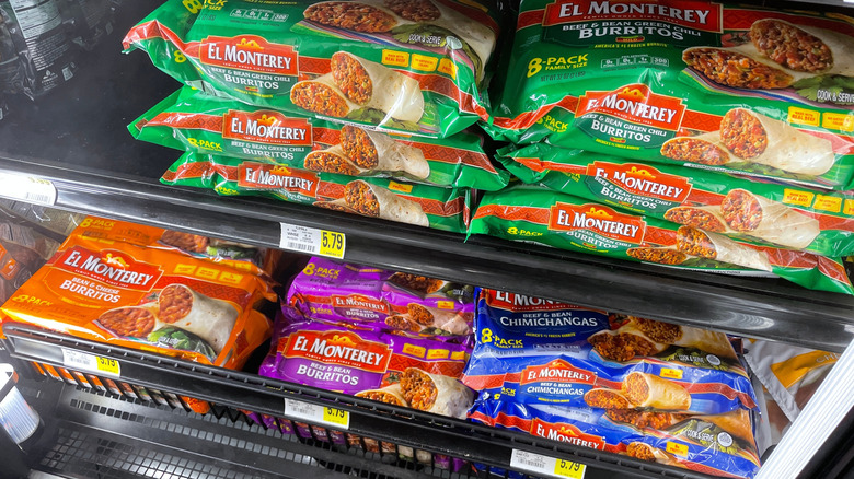 Various flavors of El Monterey frozen burritos in the freezer aisle.