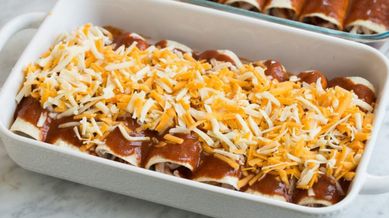 Enchiladas in a white baking dish.