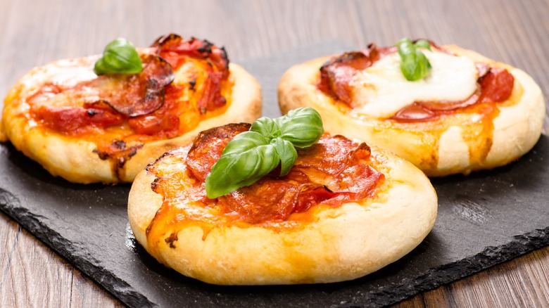 Mini pizzas on a black serving platter