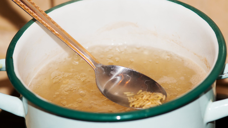 Brown rice boiling in large pot